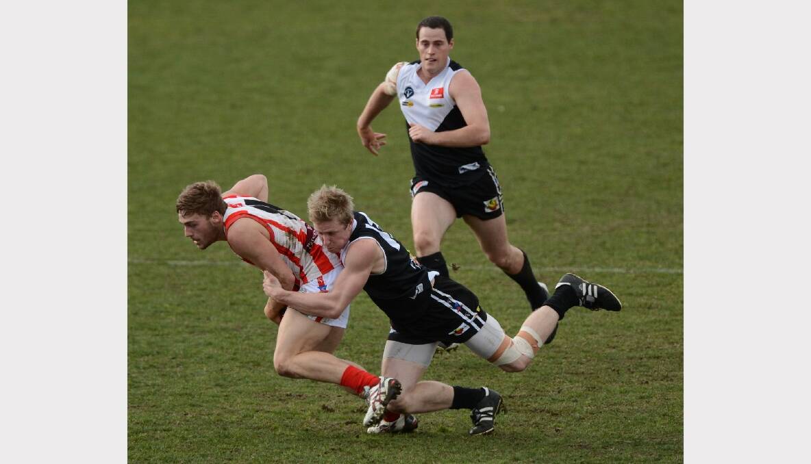 Ballarat Swans's Braeden Deary being tackled by North City's Ryan Luke as Brendan Howard watches on. PICTURE: ADAM TRAFFORD. 