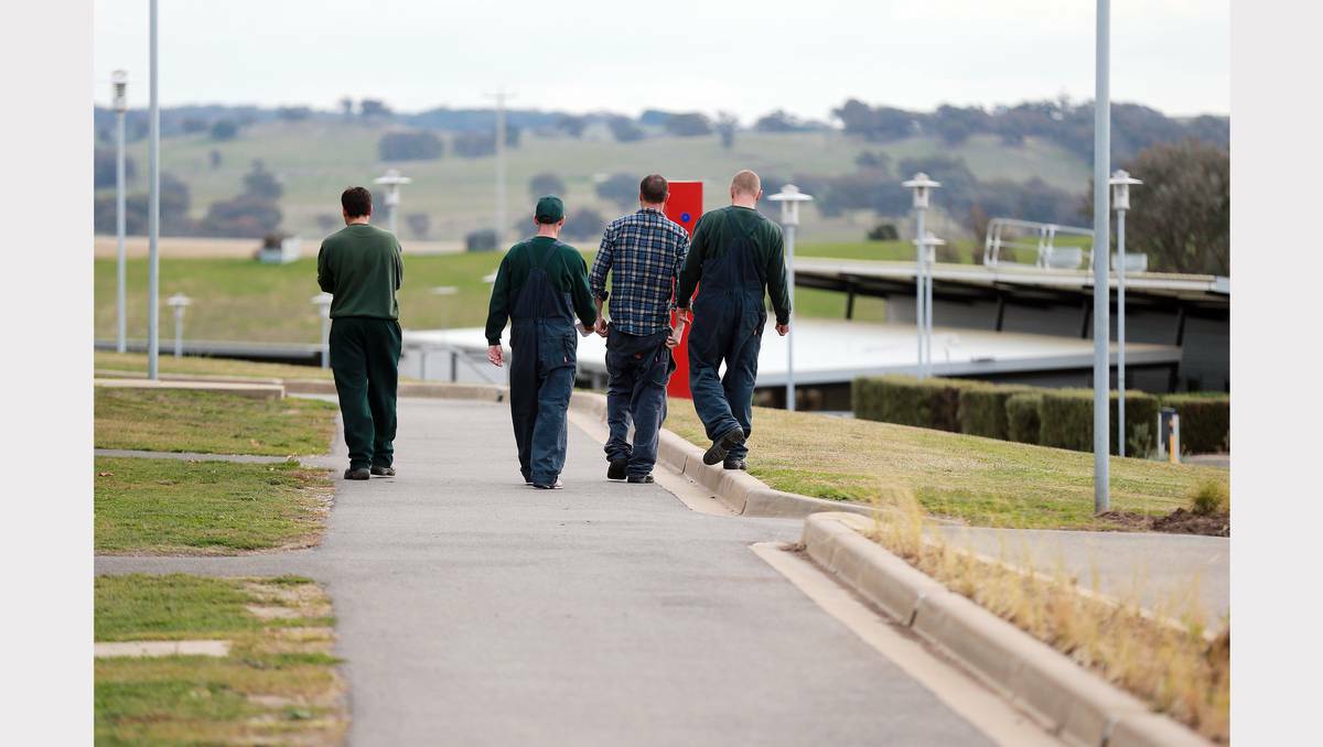 A group of inmates walk together after the gangs come back from a days work.