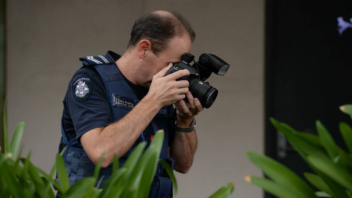 Police taking photos of the scene after a woman was slashed. PICTURE: KATE HEALY