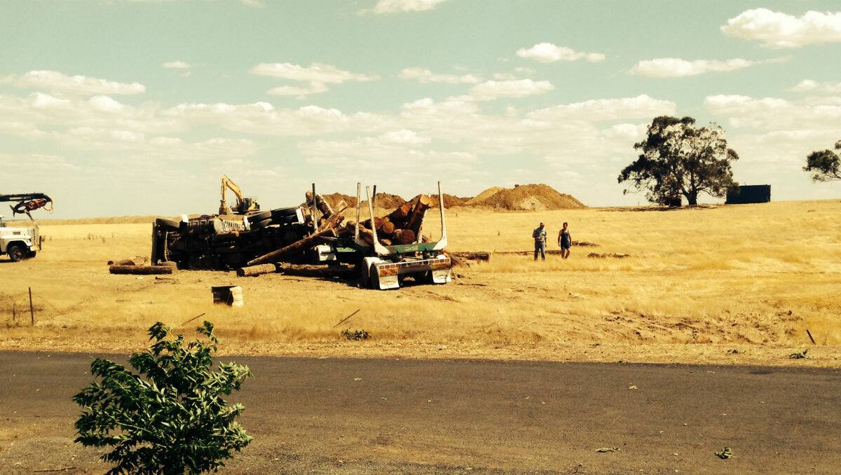 The logging truck at the side of the road after it rolled, as seen from the pub. PICTURE: DEBBIE KENDELL