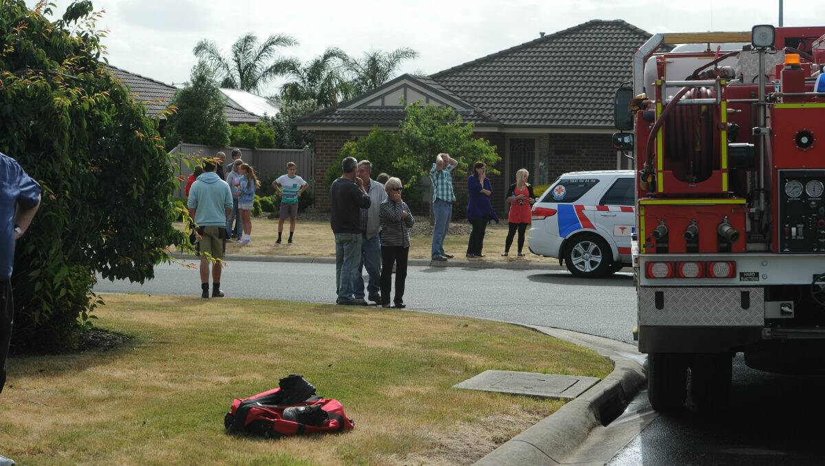 Bystanders watch as firefighters battle a house fire at Invermay Park this afternoon. PICTURE: JUSTIN WHITELOCK