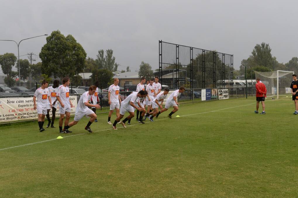 Ballarat Red Devils warming up at Kingston Heath, in the rain, for NPLV debut. Photo: Kate Healy