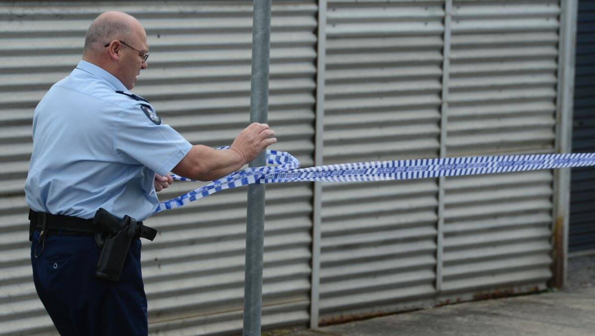 A police officer cordons off the crime scene at Black Hill Post Office. PICTURE: KATE HEALY