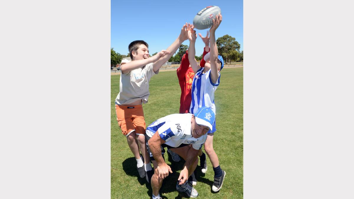 Jake McDonald, 13, Jordan Sanders, 12,  and Josh Johnson, 12 with North Melbourne's Brent Harvey at the Specialist School. PICTURE: KATE HEALY