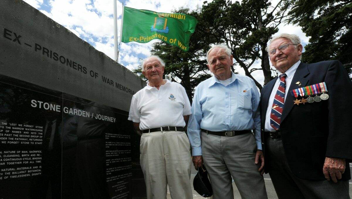 Flag: Ex-POW David Manning, memorial board chairman Les Kennedy and internee Bruce Clifton with the flag at the memorial. PICTURE: JEREMY BANNISTER