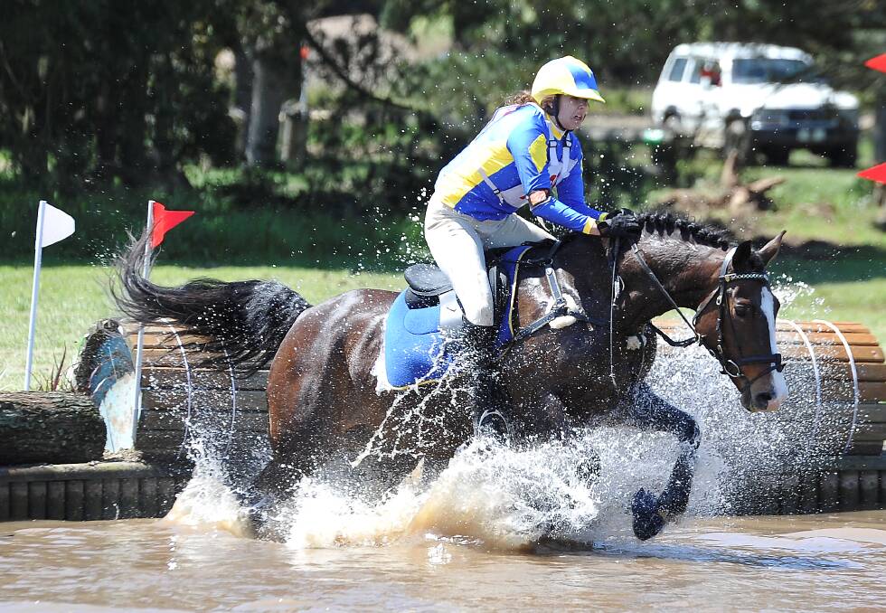  Ballarat Pony Club’s Anthea Stevens takes her horse Lola through a water obstacle during the trials. PICTURE: LACHLAN BENCE