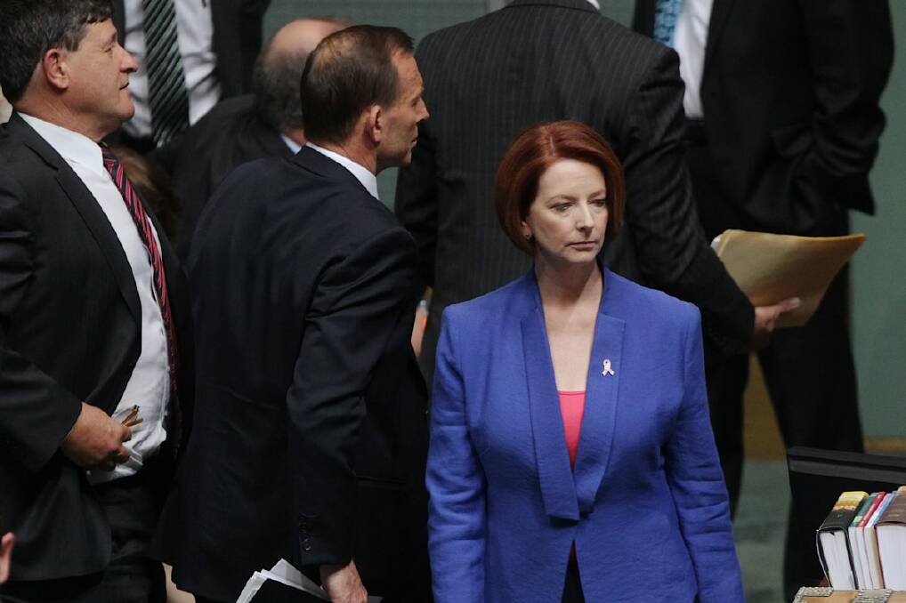 Opposition leader Tony Abbott and Prime Minister Julia Gillard cross paths in Parliament House, Canberra, in October last year.