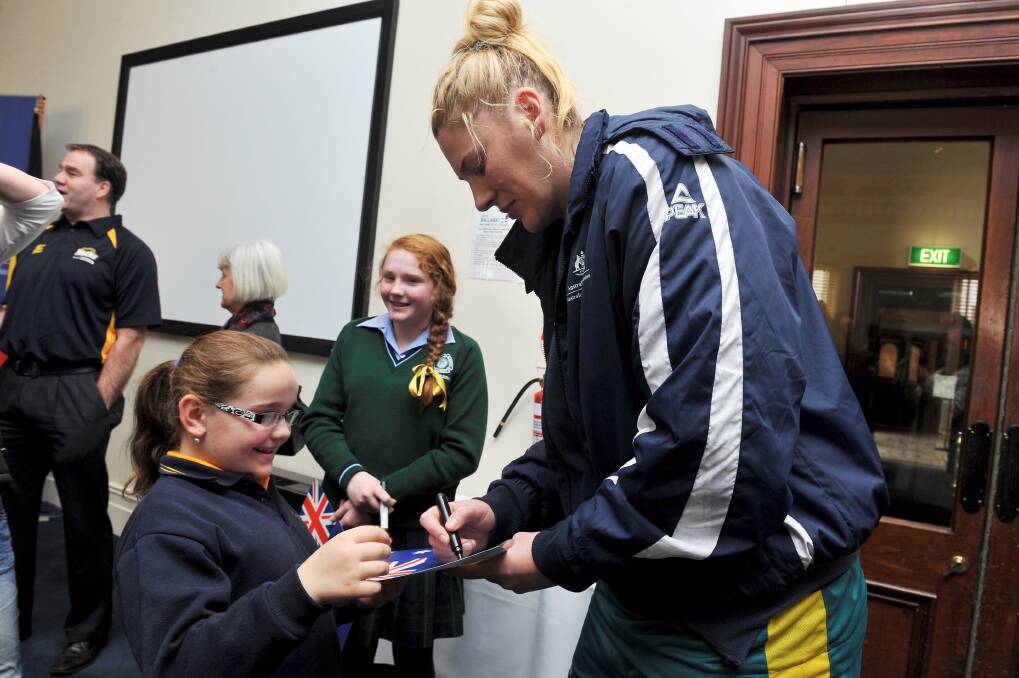  Australian Opals superstar Lauren Jackson signs an autograph for Olivia Hillas, 8, during the civic reception at the Town Hall yesterday.