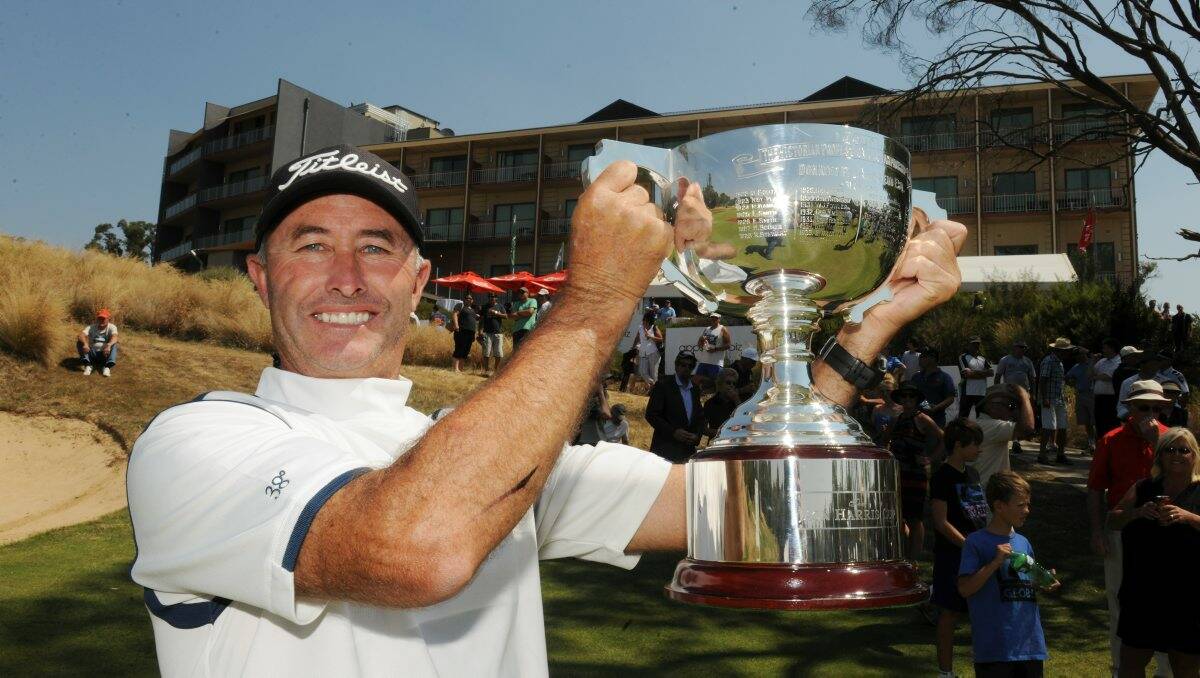 Melbourne’s David McKenzie holds the Jack Harris Cup aloft after breaking through yesterday to win the Victorian PGA Championship at Creswick’s Forest Resort. Picture: Lachlan Bence