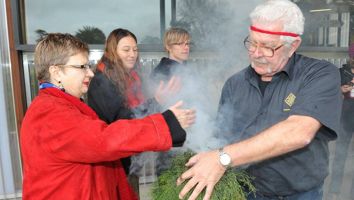 Recognition:  M.A.D.E director Jane Smith and Bryon Powell perform a smoking ceremony yesterday. PICTURE: LACHLAN BENCE