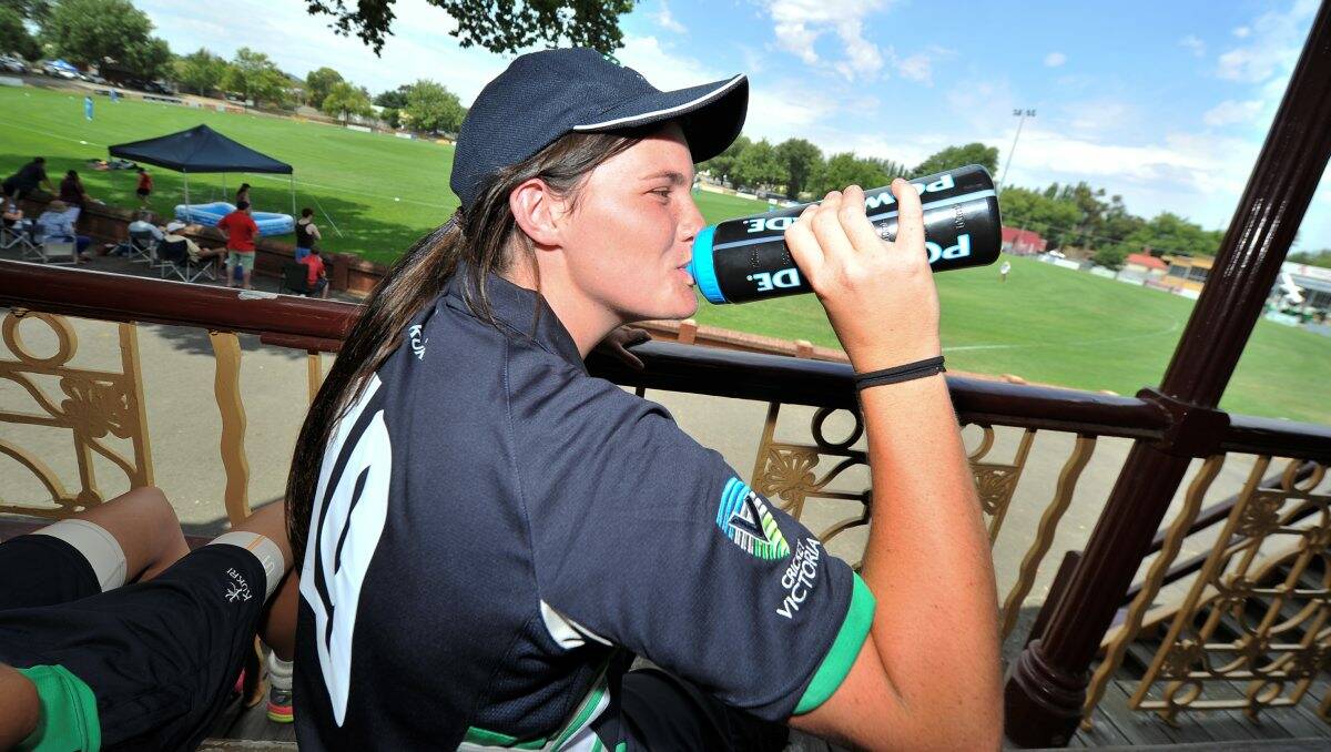 Player Hope Irvine combats the heat with a cool drink.