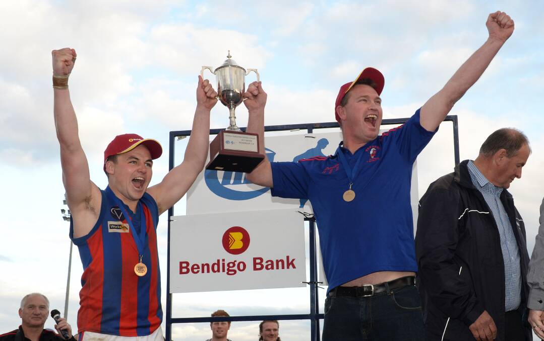 Hepburn captain Dan O’Halloran and coach Clive Raak show off the premiership cup.